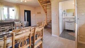 Un intérieur en bois comprenant un coin repas, un escalier et une cuisine.