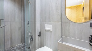 A modern bathroom with a glass shower enclosure, a white sink, and a large mirror. - Modern & cosy apartment with designer lounge - Ideal for a relaxing break (Marrakech Gueliz)