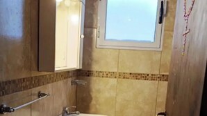 A bathroom with a sink, mirror, and window. - Bright Apartment with Green View, AC and WiFi - Close to the Beach Resort (Río Tercero)