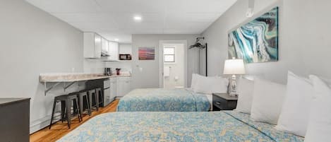 A bedroom with two beds, a desk, and a chair.