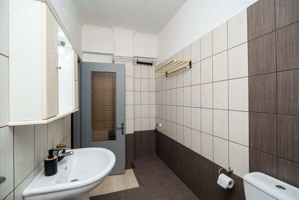 Un baño moderno con lavamanos blanco, toallero y retrete.