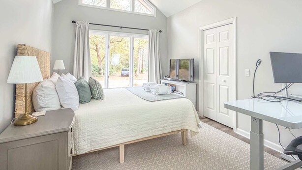 A bedroom with a bed, a desk, a television, and a ceiling fan. - Quiet Sea Pines Home: Screened Porch + Beach Gear (Hilton Head Island)