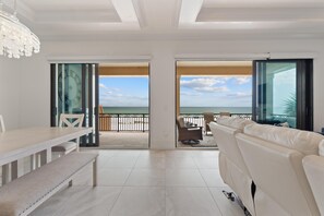 A spacious living area with a balcony, a dining table, and a sofa. - Blue Paradise (Fort Myers Beach)