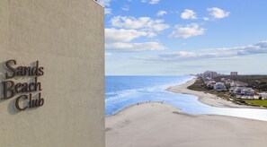 Une vue sur la plage avec un panneau indiquant « Sands Beach Club ».