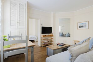 A well-lit room with a bed, a desk, a television, and a sofa. - Incredibly Located 1BDR Hideaway in Soho (Greater London)