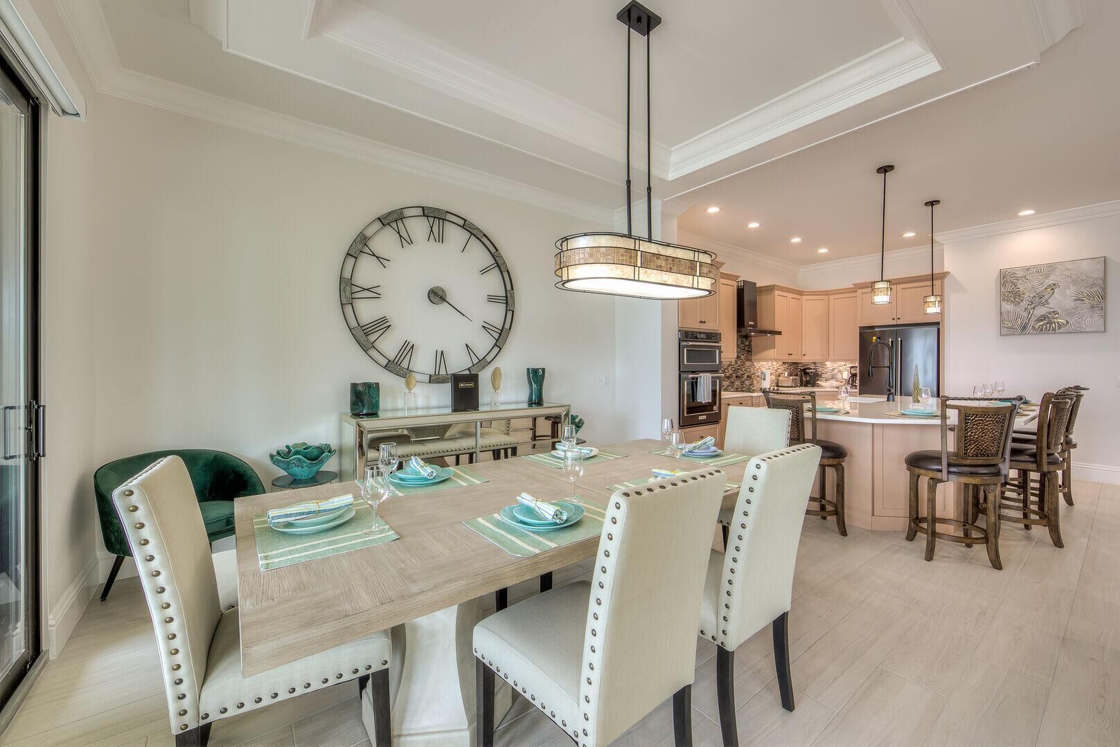 Un comedor con un reloj de pared grande, una mesa de madera y sillas.