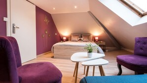 Un dormitorio con cama, mesitas de noche, tragaluz y vistas al cielo.