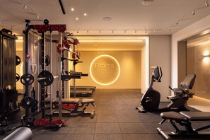 A gym with weightlifting equipment, cardio machines, and a motivational 'Fitness' sign. - Desert View Home • Private Balcony by SeaNRent (Eilat)