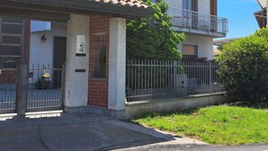 Un immeuble résidentiel de deux étages, doté d’un toit en tuiles, d’une façade en briques et d’une clôture en métal.