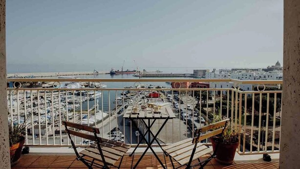 A balcony with a view of a marina and a cityscape. - Endless Charm by Monholiday (Monopoli)