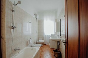 Ein modernes Badezimmer mit Badewanne, Dusche, Bidet und Waschbecken.