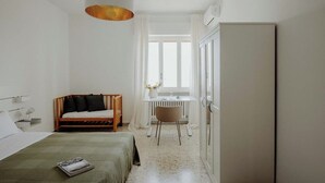 A bedroom with a bed, a desk, a chair, and a wardrobe. - Endless Charm by Monholiday (Monopoli)