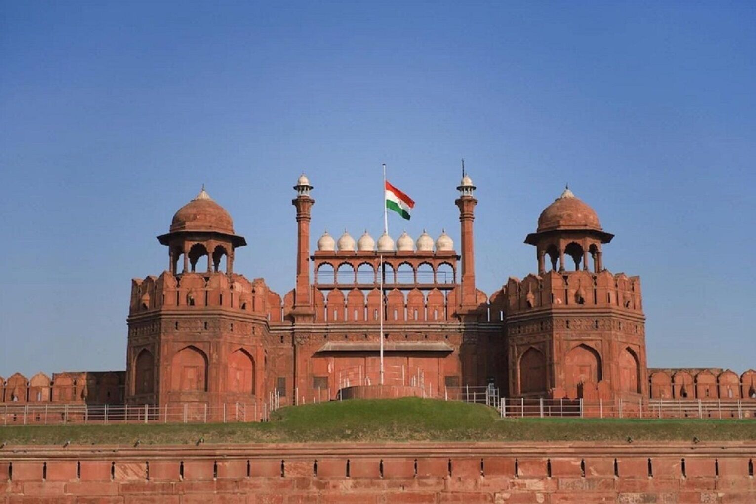 A large, historic building with two prominent domes and a central archway.