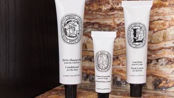 Trois tubes de produits de toilette sur un comptoir en marbre.