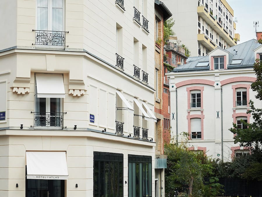 Ein Hotel mit weißer Fassade, mehreren Balkonen und einer Kopfsteinpflasterstraße davor.