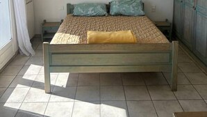 Un dormitori amb un llit, un quadre a la paret i un armari.