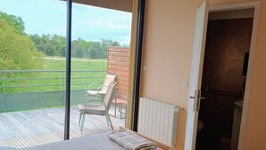 Ein Schlafzimmer mit zwei Betten, Blick ins Freie und einer Tür zum Badezimmer.