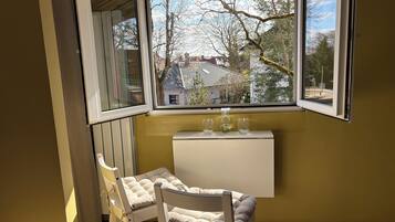 Ein Zimmer mit Fenster, Heizkörper und zwei Stühlen.