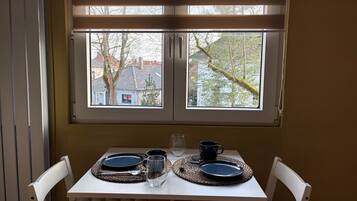 Ein Esstisch mit zwei Tellern, zwei Gläsern und einer Tasse, gedeckt für zwei Personen.