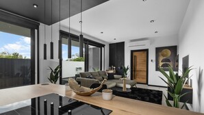 Ein modernes Wohnzimmer mit einem Glastisch, einer Couch und einem großen Fenster.