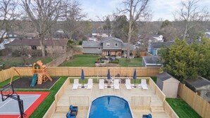 A backyard with a swimming pool, a basketball court, and a children's play area. - Pickleball-Basketball-Pool-HotTub-GameRoom-FirePit (Columbus)