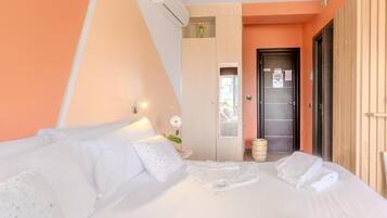 A hotel room with a bed, a wardrobe, a mirror, and a door.