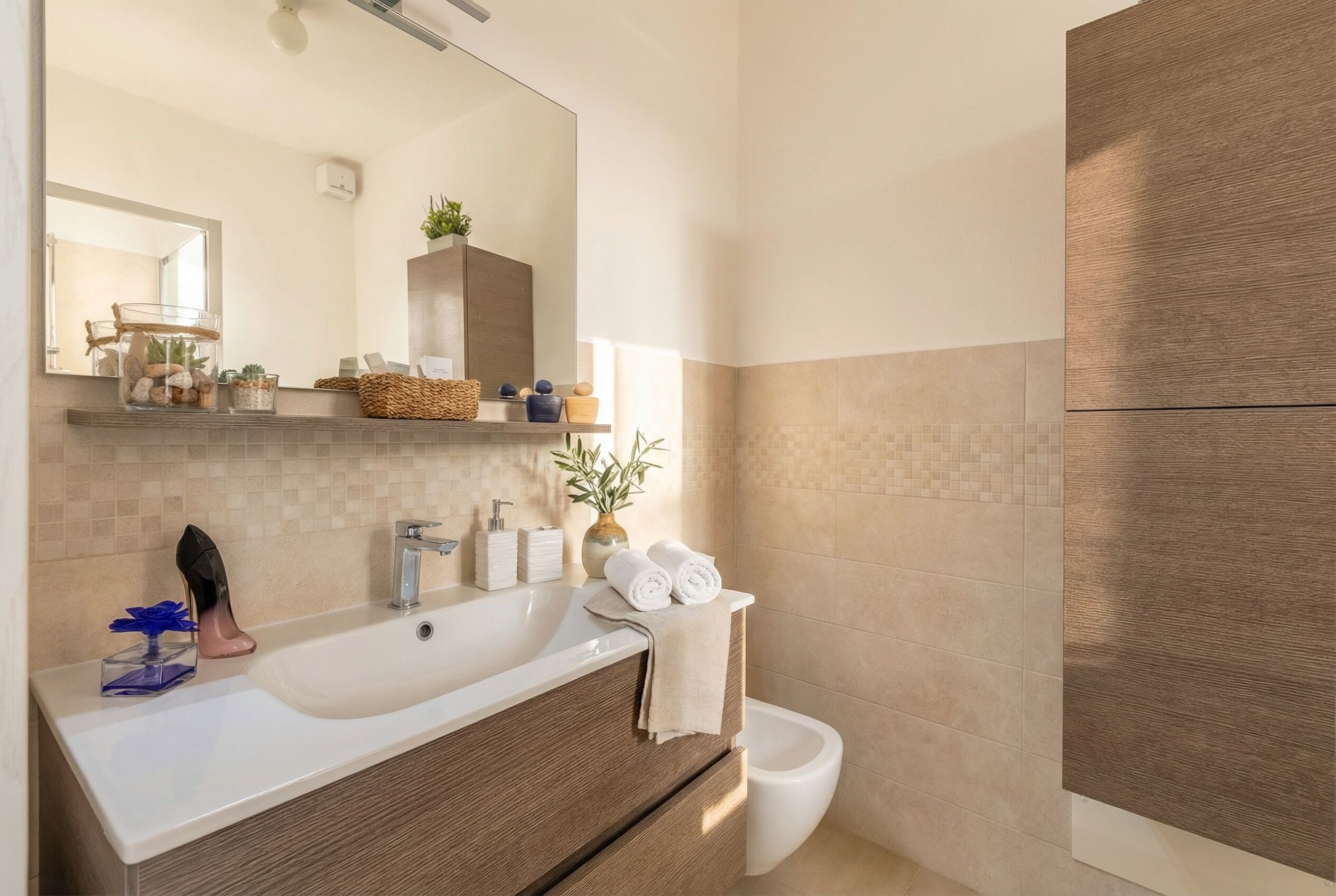 Une salle de bain moderne avec un grand lavabo, un miroir et un meuble en bois.