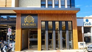 The exterior of Oumel Hotel with a modern facade, large windows, and a visible entrance. - HOTEL OURO MEL (Santa Bárbara)