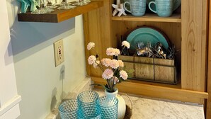 A kitchen with wooden shelves holding glassware and dishes.