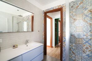 Een douche, een bidet, handdoeken, shampoo