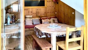 Ein gemütlicher Holzraum mit einem Bett, einer Bank und einem Tisch.