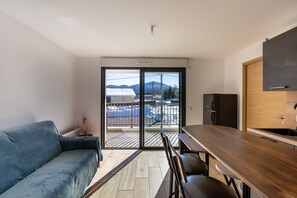 A modern kitchen with a wooden countertop and a built-in oven. - Le Nid des Pyrénées - Proche des Angles (Fontrabiouse)