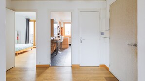 Un soggiorno open space con tavolo e sedie, angolo cottura e camera da letto con letto e finestra.