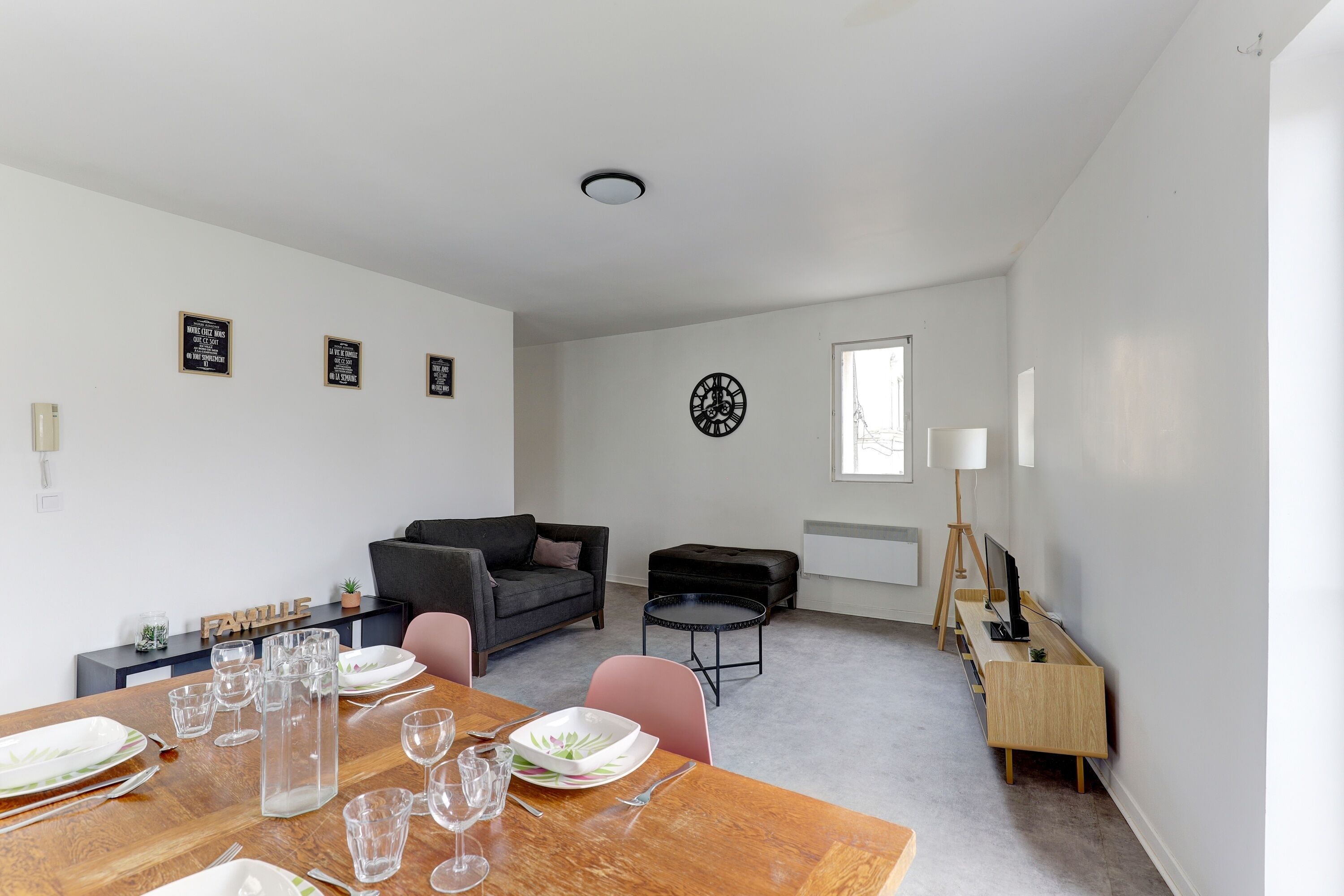 Un soggiorno moderno con zona pranzo, divano, tavolino e mobile TV.