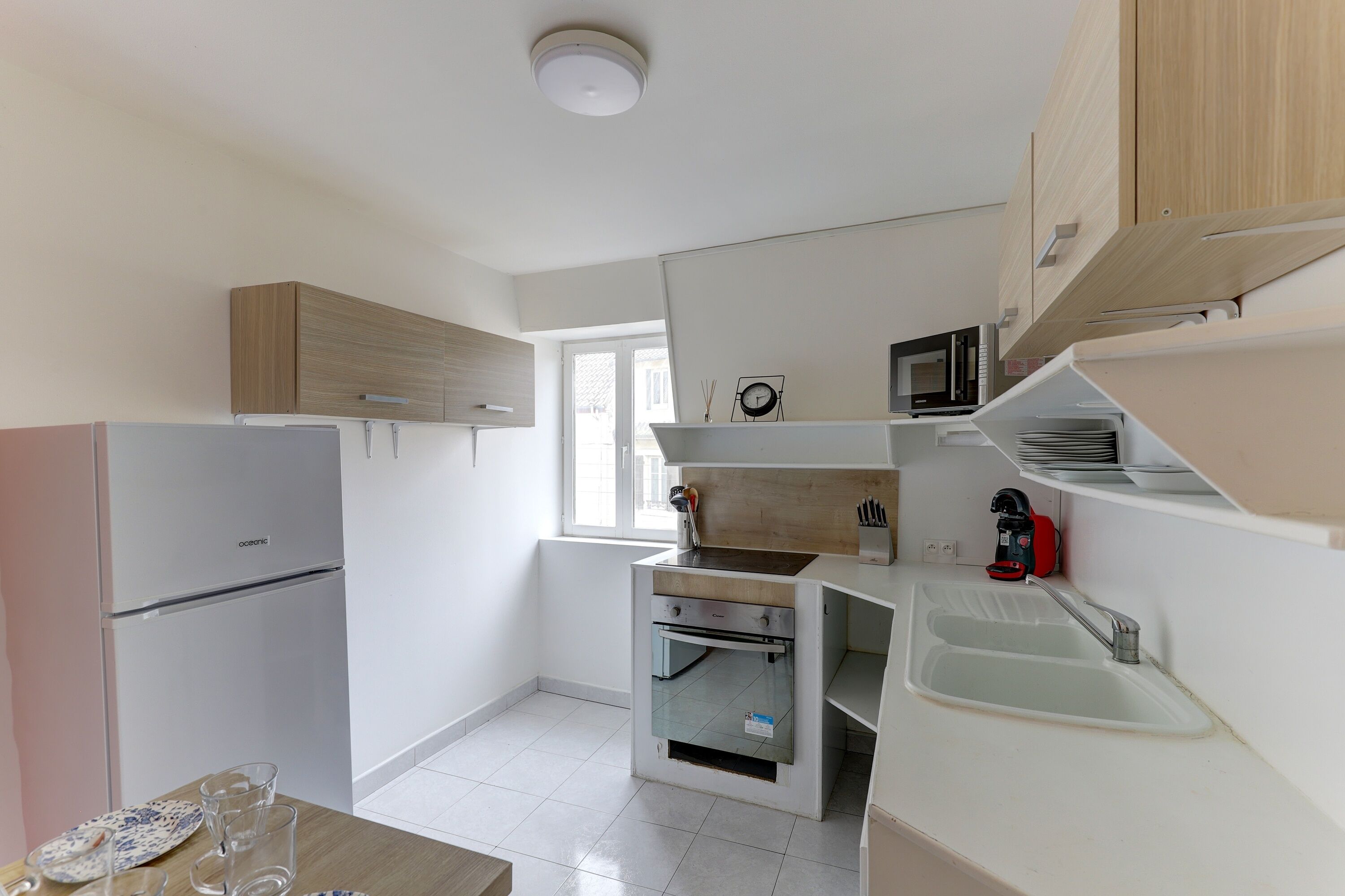 A modern kitchen with built-in appliances, a window, and a sink.