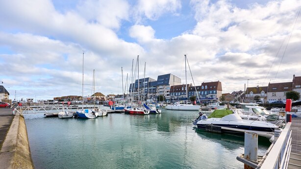 A marina with multiple boats docked, a wooden walkway, and buildings in the background. - Les Camélias - 5min à pied du Port (Courseulles-sur-Mer)