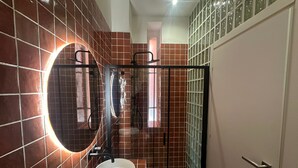 A bathroom with a round mirror, a sink, and a shower area. - Atelier 12 - by Be Your Home (Milano)
