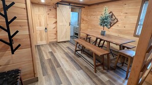 Een houten interieur met een eethoek, banken en een kleine plant in een pot.