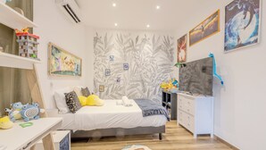 Un dormitorio con cama, escritorio y estanterías llenas de juguetes.