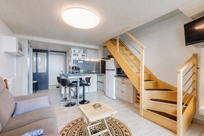 A modern apartment with a living room, kitchen, and a wooden staircase. - Panorama Marin - Parking - Mer (Bretignolles-sur-Mer)