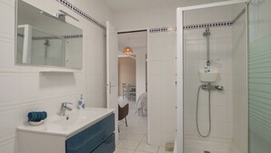 A bathroom with a sink, mirror, and shower. - L’écrin - Climatisation - Jardin (Baillif)