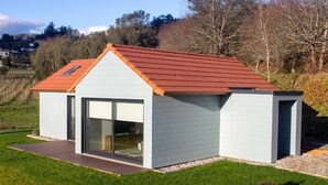 A modern single-story house with a red roof, large glass sliding doors, and a small porch area. - CasadoZé - Ihr privates Ferienhaus mit Pool und Gartenblick in Arcos de Valdevez (Arcos de Valdevez)