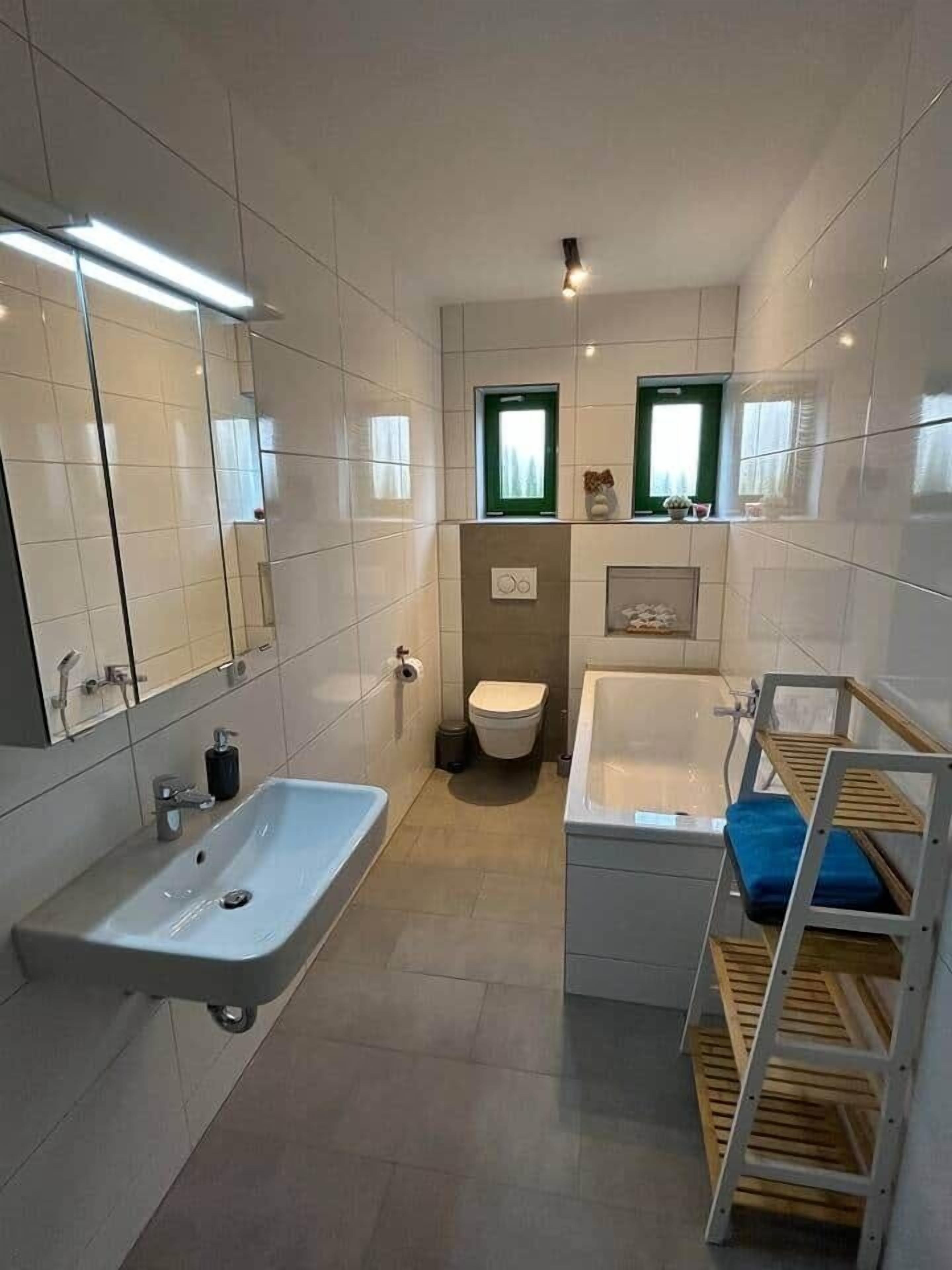 Un baño moderno con un lavamanos grande, inodoro y bañera.