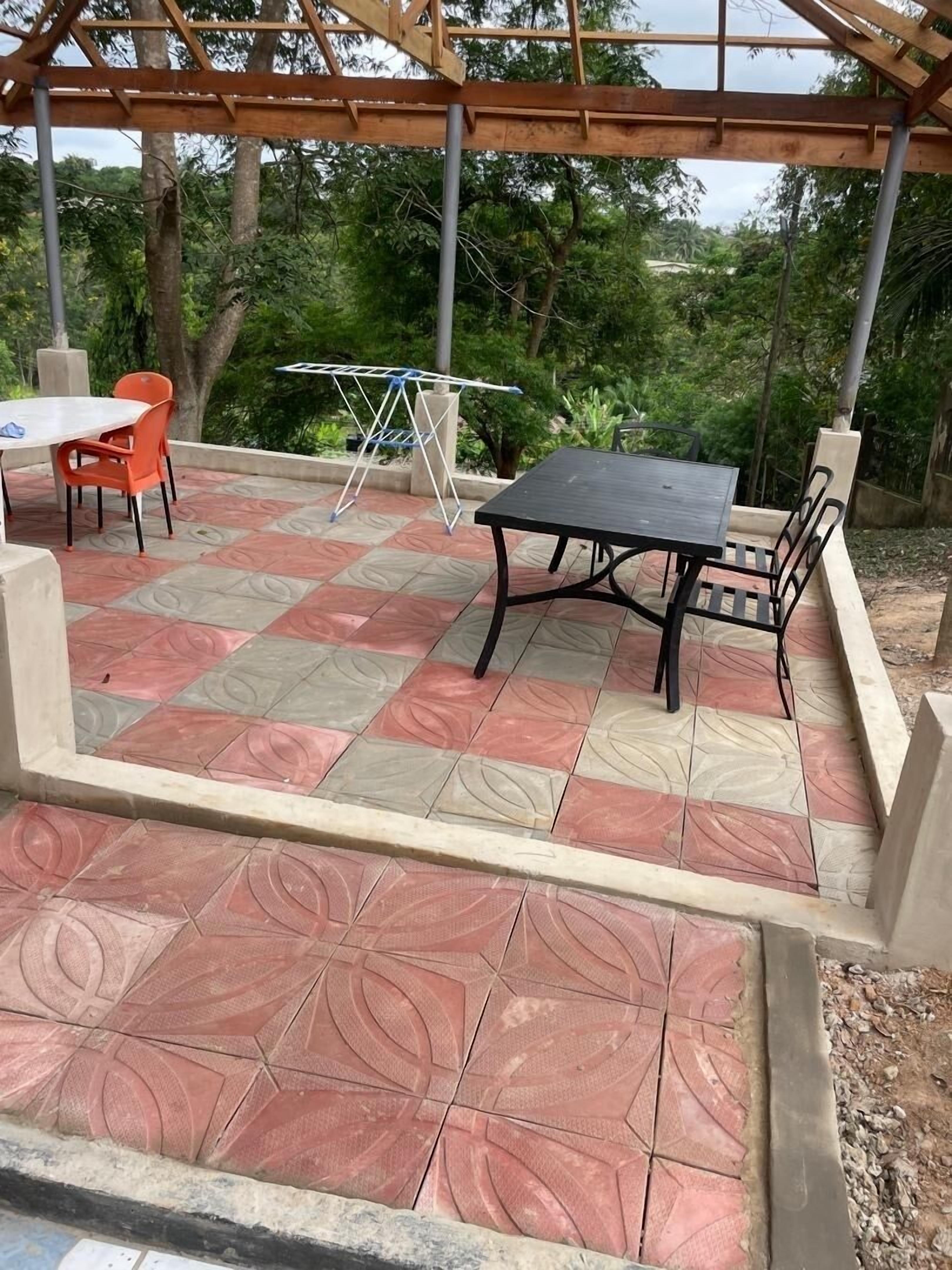 An outdoor patio with a table and chairs, a drying rack, and a pergola structure.
