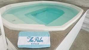 Una vasca idromassaggio con un asciugamano blu con scritto sopra "The Palm Royale".