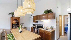 Una cucina moderna con mobili in legno, un'isola centrale e luci a sospensione.