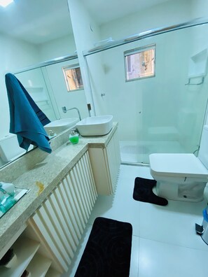 A bathroom with a sink, mirror, and toilet.