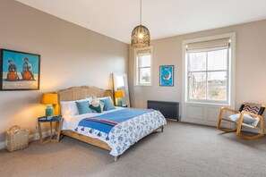 A bedroom with a bed, bedside lamps, a window, a radiator, a chair, and artwork on the walls. - Emley Woodhouse - Seven Bedroom Villa, Sleeps 17 (Emley)