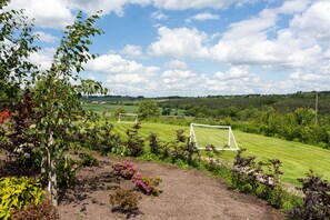 A soccer field with two goals, surrounded by lush greenery and a clear sky. - Emley Woodhouse - Seven Bedroom Villa, Sleeps 17 (Emley)