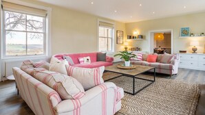 A living room with two sofas, a coffee table, and a bookshelf. - Emley Woodhouse - Seven Bedroom Villa, Sleeps 17 (Emley)